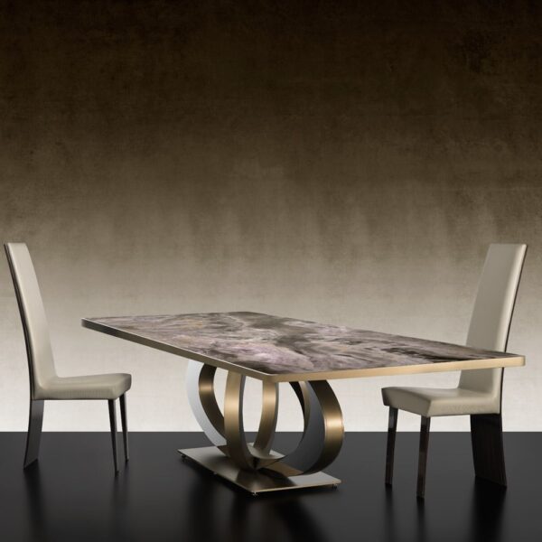 An Italian marble dining table with a thick, polished top. The table's base features intertwined, curved metal supports.