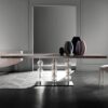 A minimalist table with a rectangular wooden tabletop and a unique base made from stacked, clear glass spheres.